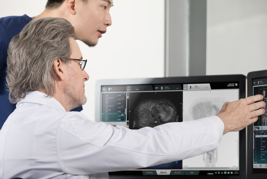 Two medical staff are looking at the Wide-bore 1.5T MR screen.